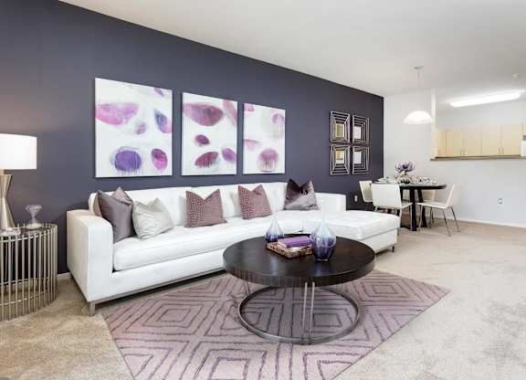 Living room with white sectional and purple accents at La Jolla Crossroads Apartments, San Diego, CA 92122