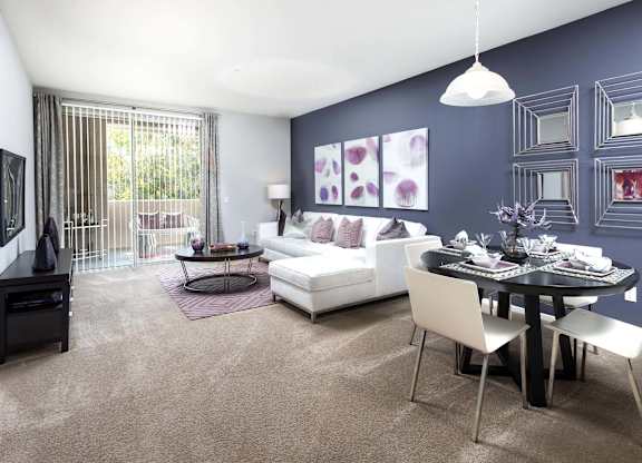 Living and dining area with purple accent wall at La Jolla Crossroads Apartments, San Diego, CA