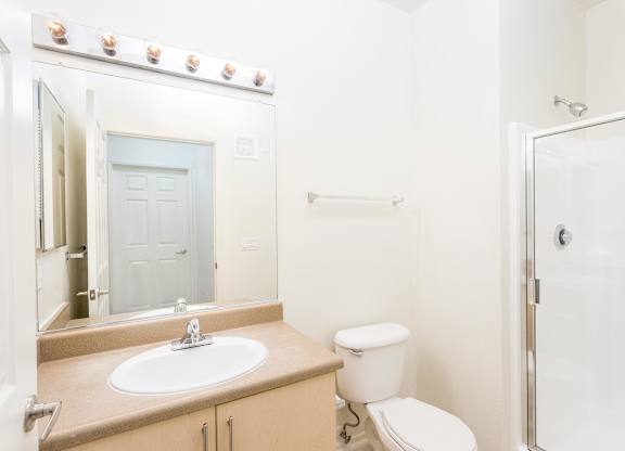 Bathroom with vanity sink and glass shower enclosure at La Jolla Crossroads Apartments, San Diego, California