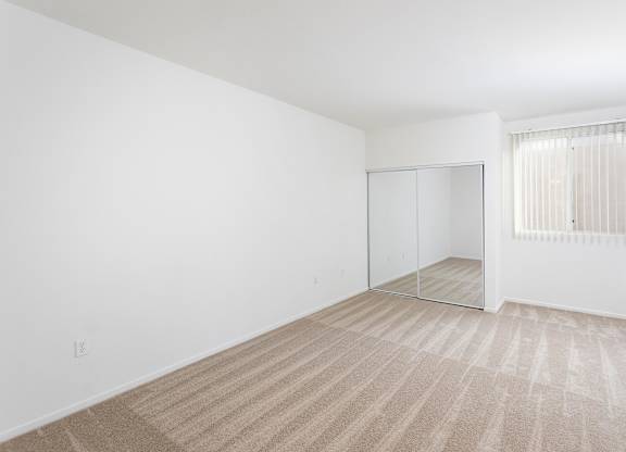 Empty bedroom with mirrored closet and window at La Jolla Crossroads Apartments, California, 92122