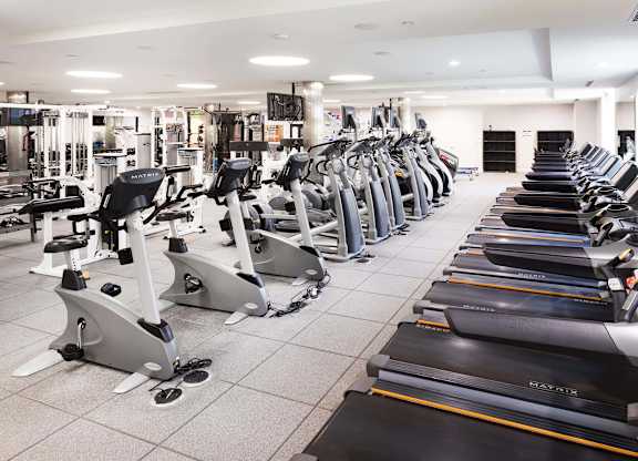 Fitness center with cardio and strength training equipment at La Jolla Crossroads Apartments, California
