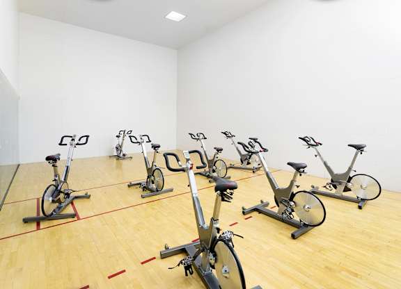 Indoor cycling studio with stationary bikes on racquetball court at La Jolla Crossroads Apartments, San Diego, CA