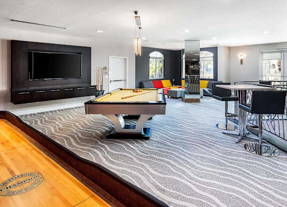 Game room with pool table and entertainment wall at La Jolla Crossroads Apartments, San Diego