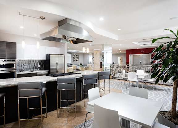 Modern community kitchen with island seating and stainless appliances at La Jolla Crossroads Apartments, California