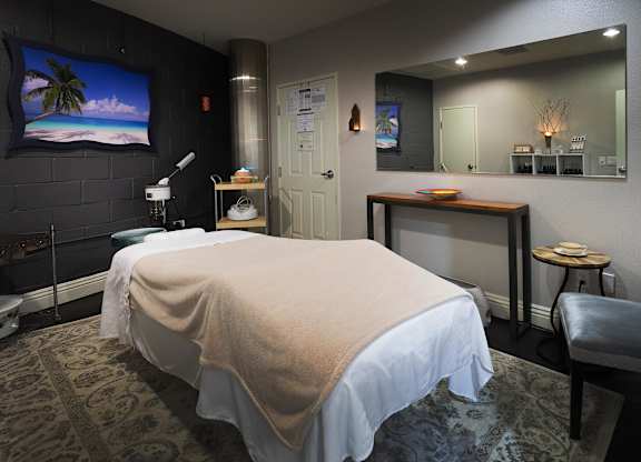 Spa treatment room with massage table and tropical screen at La Jolla Crossroads Apartments, San Diego, California