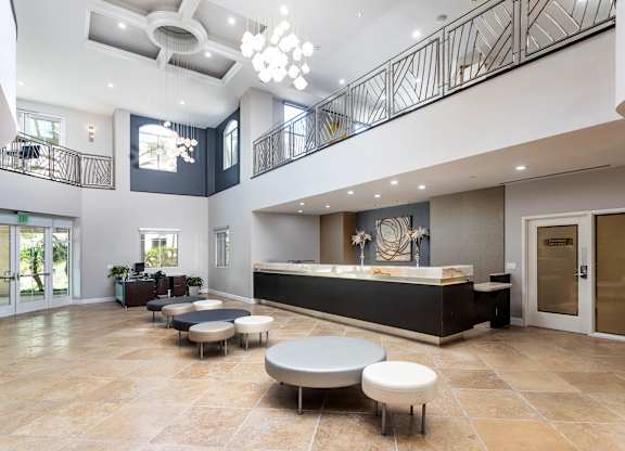 Two story lobby with reception desk and modern seating at La Jolla Crossroads Apartments, California, 92122