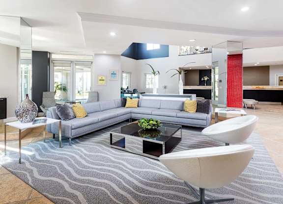 Spacious living room with gray sectional and modern furnishings at La Jolla Crossroads Apartments, San Diego, CA