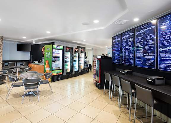 Cafe with refrigerated drinks bar seating and menu boards at La Jolla Crossroads Apartments, California, 92122