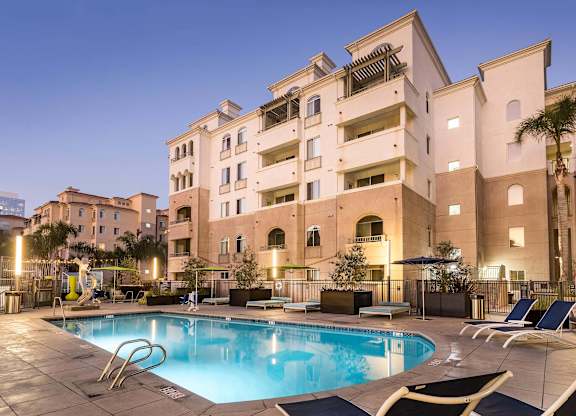 Evening view of swimming pool with lounge chairs at La Jolla Crossroads Apartments, San Diego, CA