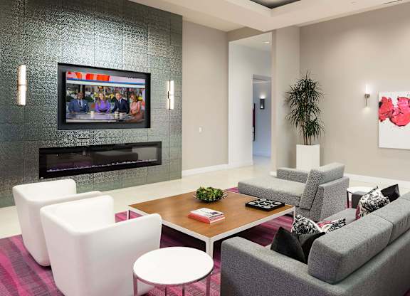 Resident lounge with seating and television at Metropolis Apartments, IRVINE, California