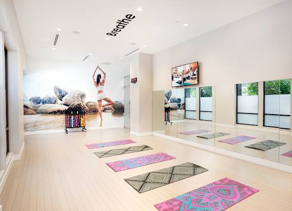 Yoga studio with mats and mirrored walls at Metropolis Apartments, IRVINE