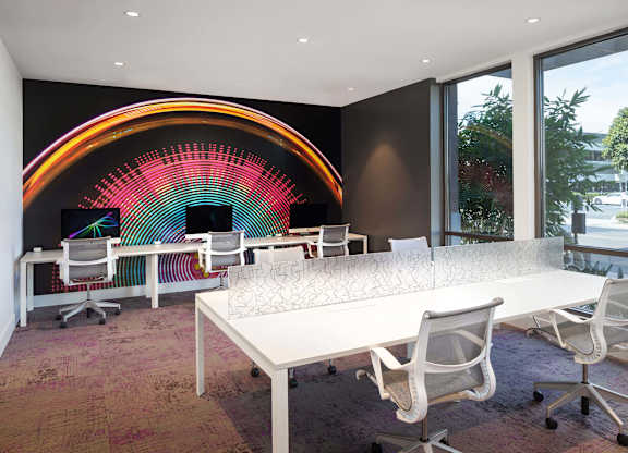 Collaborative workspace with rainbow wall art at Metropolis Apartments, California
