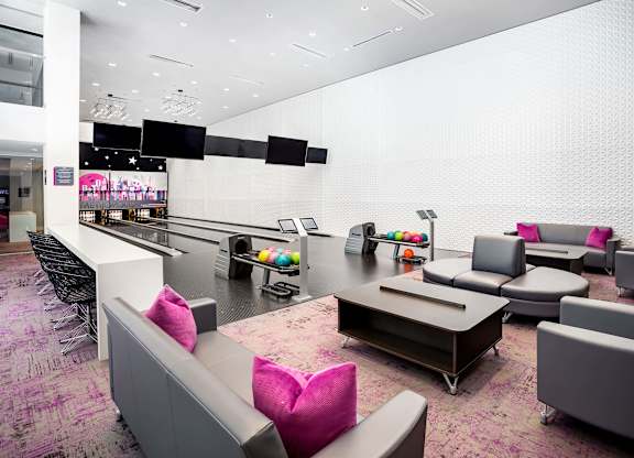 Bowling alley lounge with modern seating and lanes at Metropolis Apartments, IRVINE, CA 92614