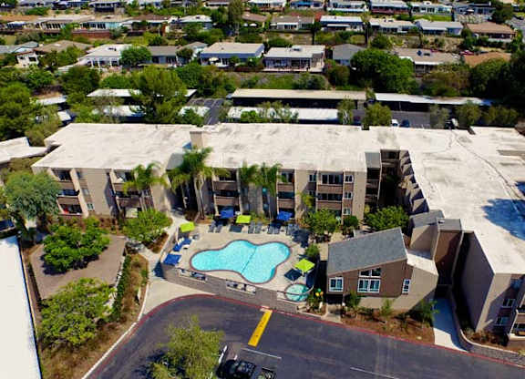 A large building with a pool in front of it.at Pacific Bay Club Apartments, San Diego, CA