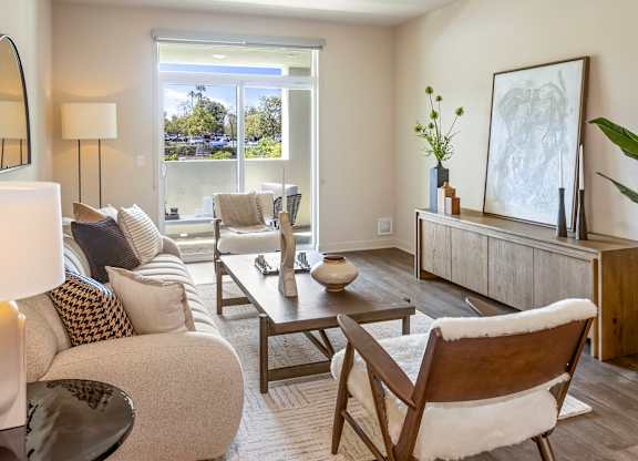Living room with modern furniture and sliding glass door at Casa Mira View Apartments, San Diego, CA 92126