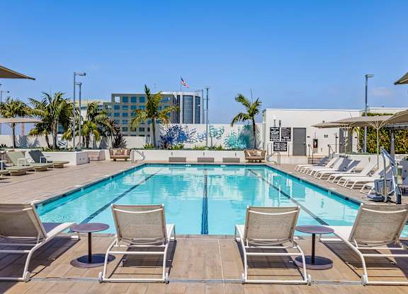 Rooftop swimming pool with lounge seating and murals at Elements Apartments, Irvine, 92612