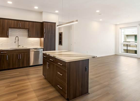 Open concept kitchen with island and pendant lighting at Elements Apartments, Irvine, CA