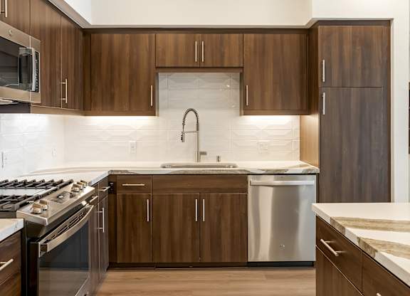Kitchen with wood cabinetry and modern appliances at Elements Apartments, Irvine, 92612