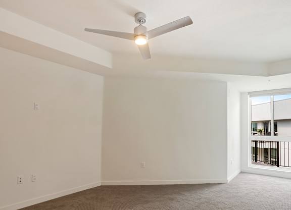 Empty carpeted room with ceiling fan and balcony access at Elements Apartments, California, 92612
