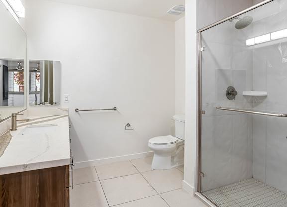 Accessible bathroom with grab bars and roll in shower at Elements Apartments, Irvine, CA