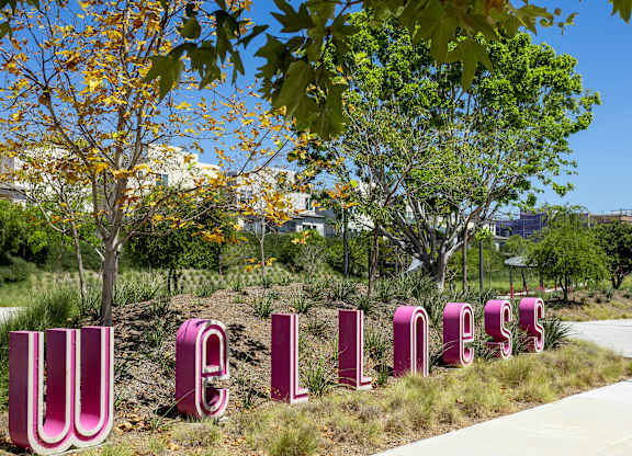 A large outdoor sign spelling "WELCOME" in pink letters.