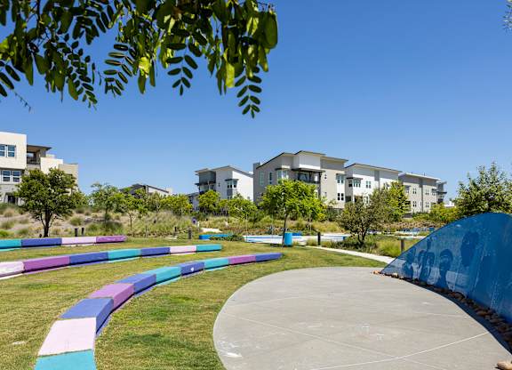 A playground with a slide and a wall with graffiti.