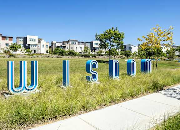 A grassy area with the letters U, I, S, D, O, M spelled out in large blue letters.