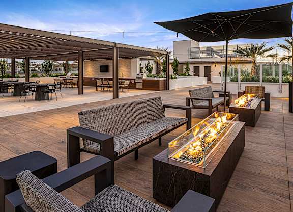 A patio with a fire pit and seating area.