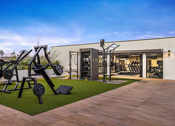 An outdoor gym with a variety of equipment including a leg press machine.