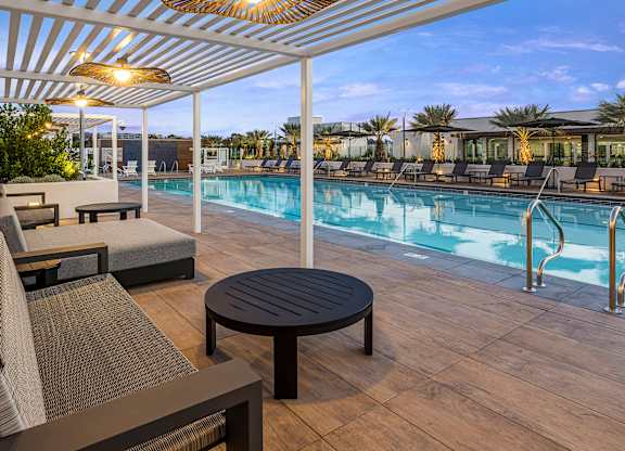 A poolside cabana with tables and lounge chairs.