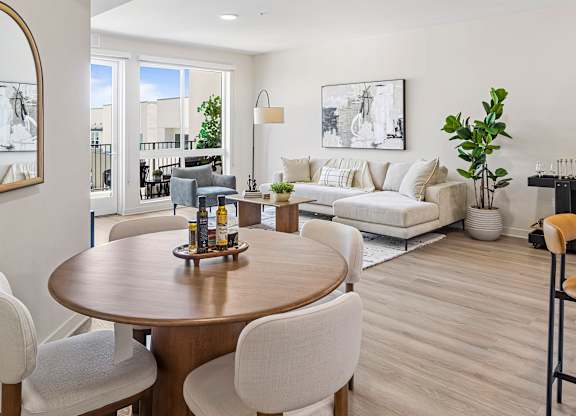 A modern dining room with a wooden table and white chairs.