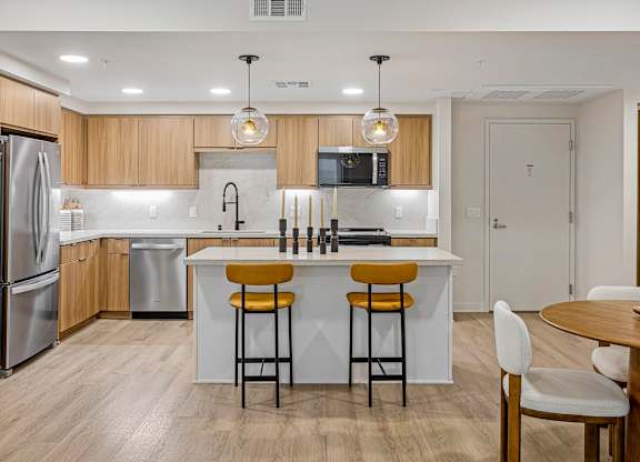 Bright kitchen with a white island and stainless-steel appliances.
