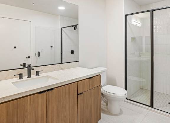 A modern bathroom with a white sink and a toilet.