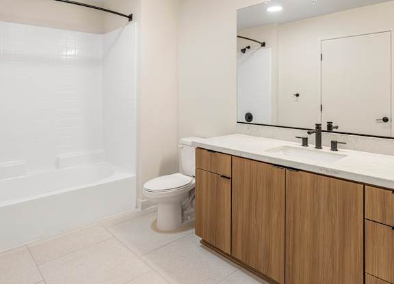 A white bathroom with a toilet, sink, and shower.