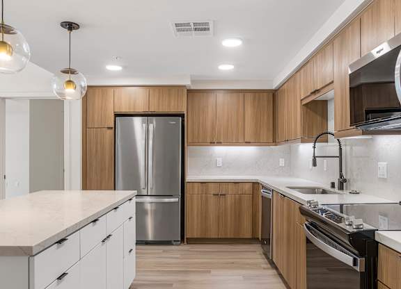 A modern kitchen with wooden cabinets and stainless steel appliances.