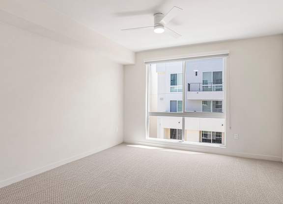 A room with a window overlooking a building.
