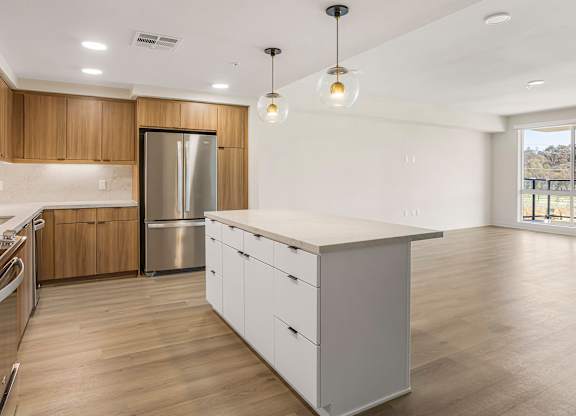 A modern kitchen with wooden cabinets and a large island.