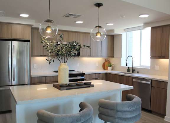 Contemporary kitchen featuring pendant lighting and island seating at Garden at 3Roots Apartments, San Diego, 92126