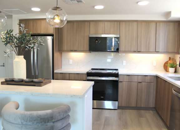 Kitchen with island seating and undercabinet lighting at Garden at 3Roots Apartments, San Diego, CA 92126