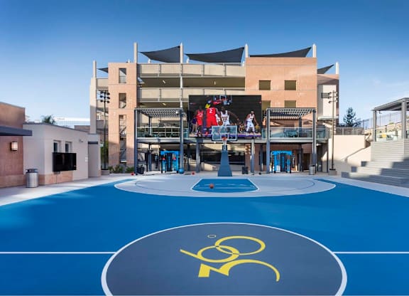 Outdoor sports court with center logo and video display at 360 Luxury Apartments, California