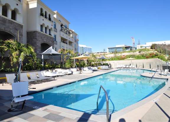 Swimming pool with lounge chairs and hillside landscaping at 360 Luxury Apartments, San Diego, CA