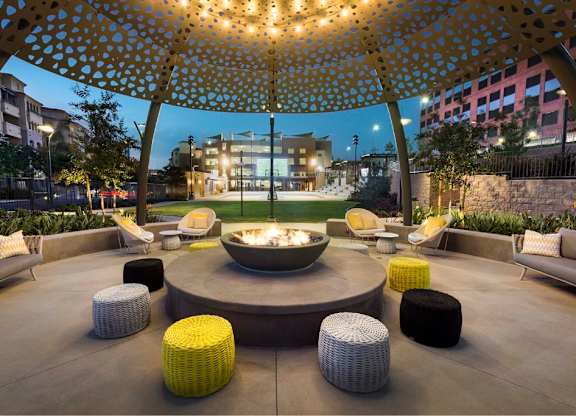 Outdoor fire pit lounge with decorative canopy at 360 Luxury Apartments, California