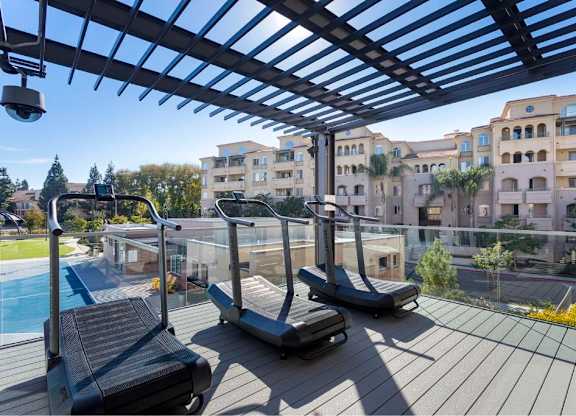 Outdoor fitness terrace with curved treadmills and views at 360 Luxury Apartments, California