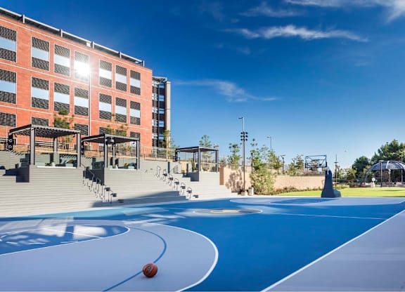 Blue basketball court with stadium seating and landscaping at 360 Luxury Apartments, San Diego, CA