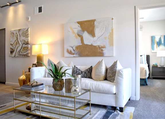 Modern living room with white sofa and gold accents at 360 Luxury Apartments, San Diego, 92122
