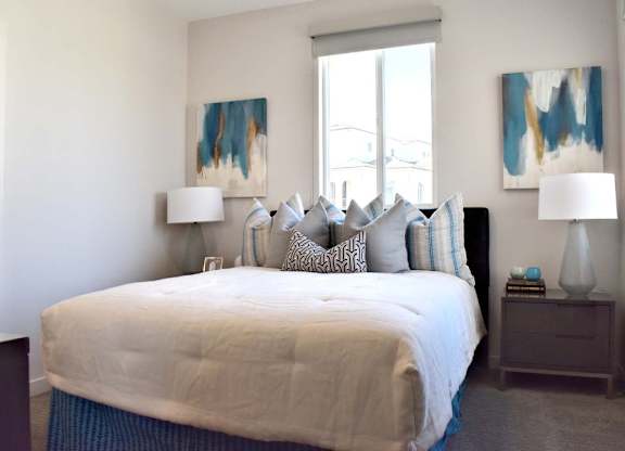 Bedroom with abstract art and upholstered bench at 360 Luxury Apartments, San Diego, California
