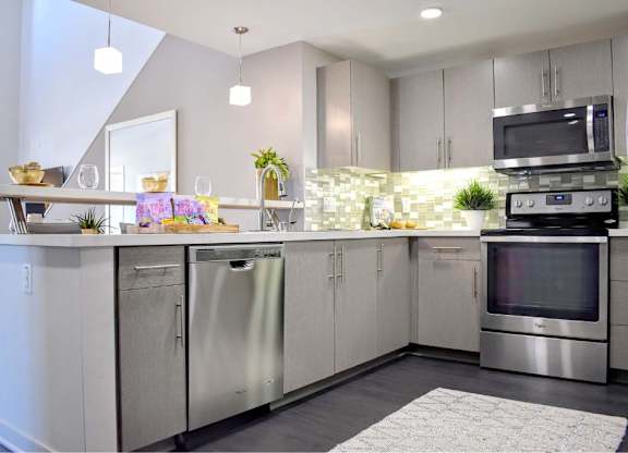 Contemporary kitchen with gray cabinets and mosaic backsplash at 360 Luxury Apartments, California