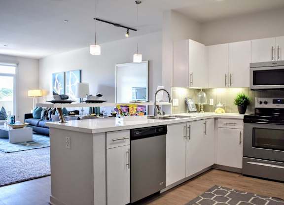 Open concept kitchen with island and living area at 360 Luxury Apartments, California