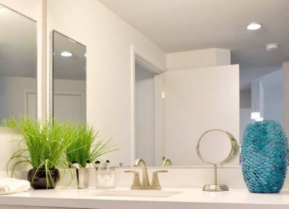 Modern bathroom vanity with white cabinetry and decorative accents at 360 Luxury Apartments, California, 92122