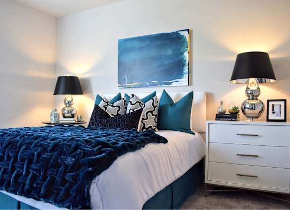 Bedroom with blue textured bedding and matching pillows at 360 Luxury Apartments, San Diego, CA 92122